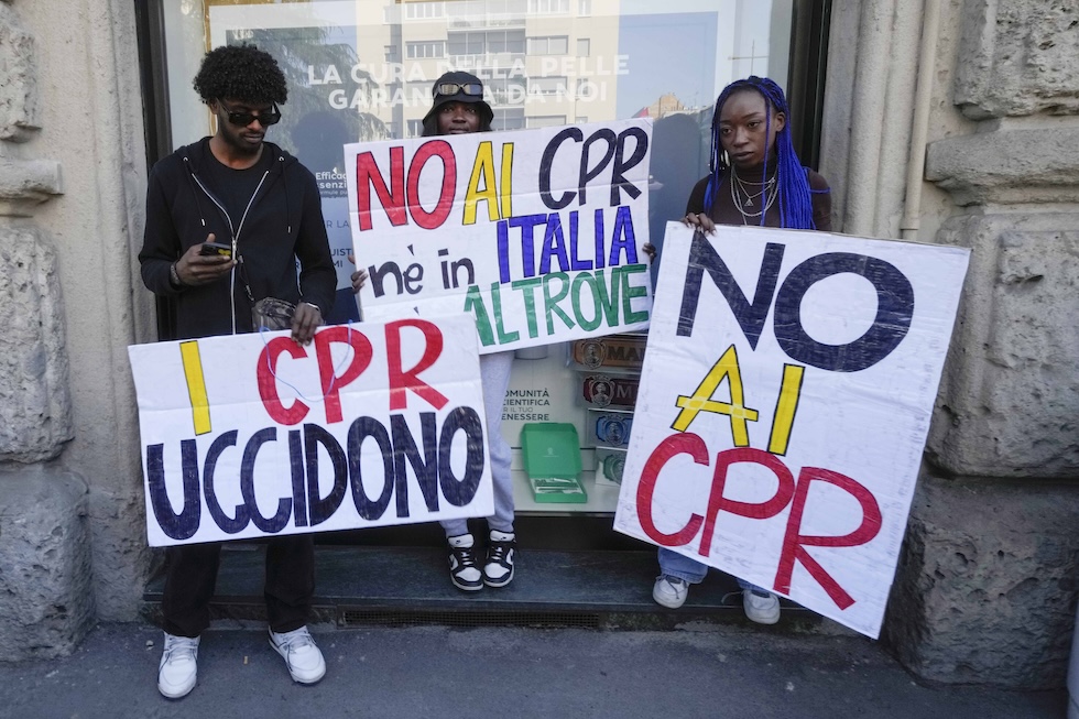 Una foto che mostra tre attivisti a una manifestazione per chiedere la chiusura di tutti i centri di detenzione temporanea per migranti, Milano, 6 aprile 2024
