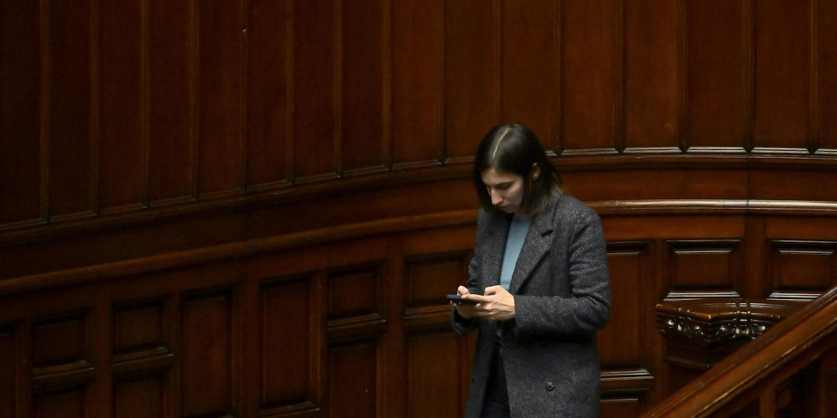 Foto di Elly Schlein alla Camera mentre messaggia al telefono