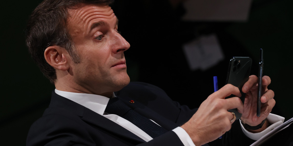 Il presidente francese Emmanuel Macron armeggia con due smartphone (Sean Gallup/Getty Images)