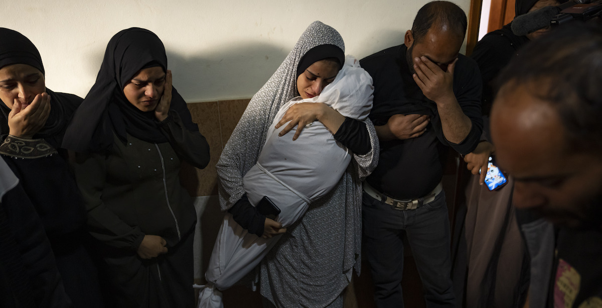 Civili palestinesi con un parente ucciso da un bombardamento israeliano a Rafah