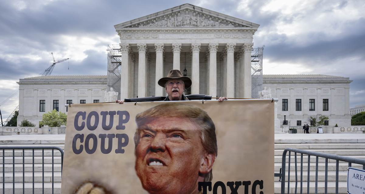Un manifestante contro Trump durante l'udienza della Corte Suprema