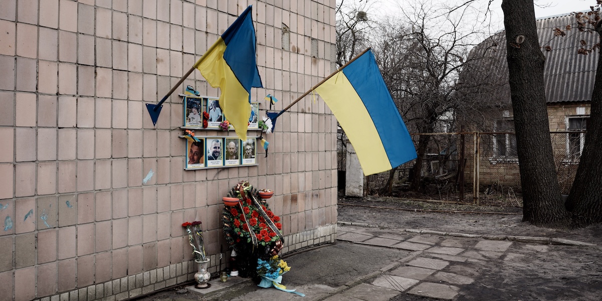 Fiori e bandiere ucraine a Bucha, nel punto in cui alcuni uomini ucraini sono stati uccisi da soldati russi (AP Photo/Thibault Camus)