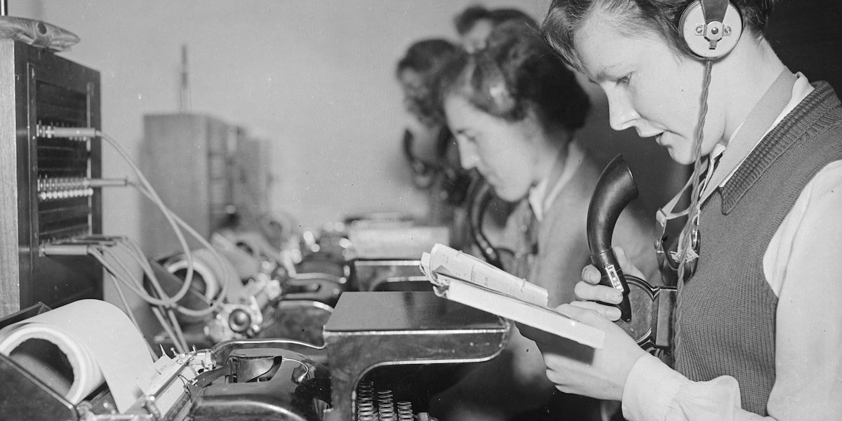 Un gruppo di impiegati postali inglesi degli anni Cinquanta trasmette e riceve messaggi telegrafici e li trascrive tramite macchine da scrivere