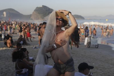 Un fan di Madonna aspetta l'inizio del concerto gratuito organizzato dalla cantante sulla spiaggia di Copacabana per celebrare la fine del suo The Celebration Tour. La foto è di sabato. (AP Photo/Bruna Prado)