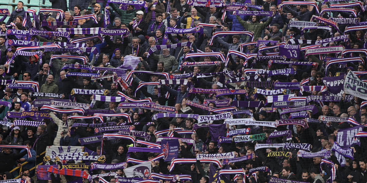 Tifosi della Fiorentina sugli spalti, esibiscono sciarpe viola