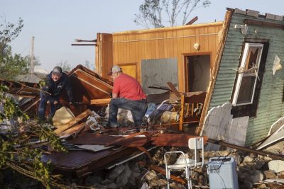 Due uomini rovistano tra le macerie della casa di una loro familiare, distrutta a causa di una forte tromba d'aria che martedì ha creato grossi danni nel nord-est dell'Oklahoma, a nord di Tulsa
