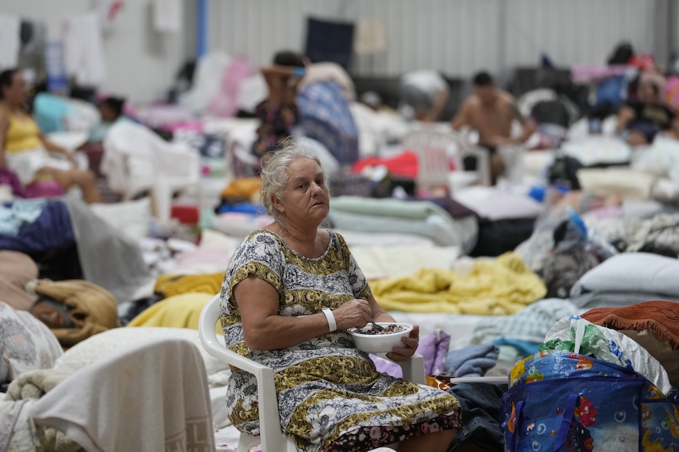 Una donna insieme ad altre persone in un rifugio allestito a Porto Alegre 