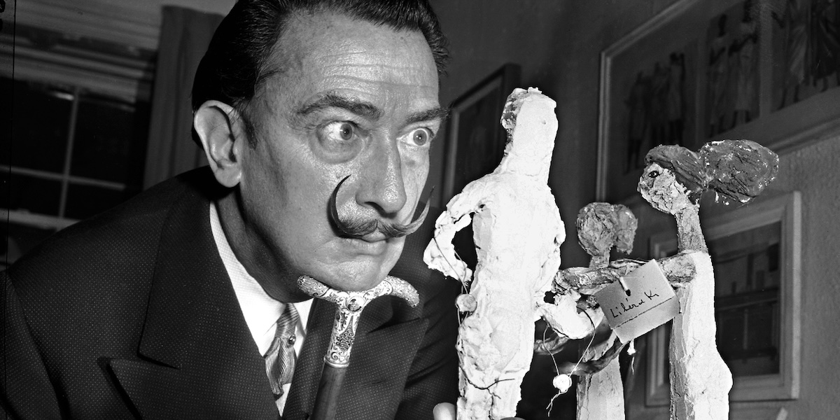 Salvador Dalí osserva delle statuette durante una mostra a New York il 4 gennaio del 1956