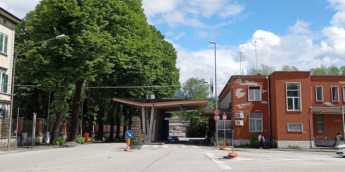 Foto del passaggio di frontiera a Gorizia, con alberi vicino e una casa rossa accanto