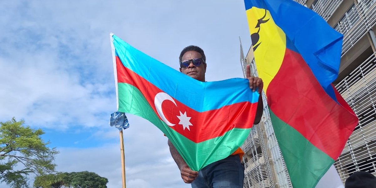 Una bandiera dell'Azerbaijan e una bandiera della Nuova Caledonia durante una manifestazione del movimento indipendentista in Nuova Caledonia a marzo del 2024 (Foto diffusa dal Baku Initiative Group su X)