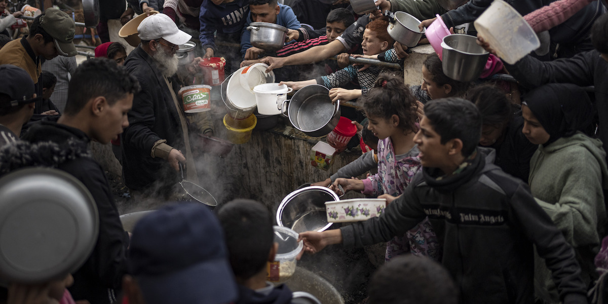 Palestinesi in fila per un pasto a Rafah, nella Striscia di Gaza, 21 dicembre 2023 (AP Photo/Fatima Shbair, File)