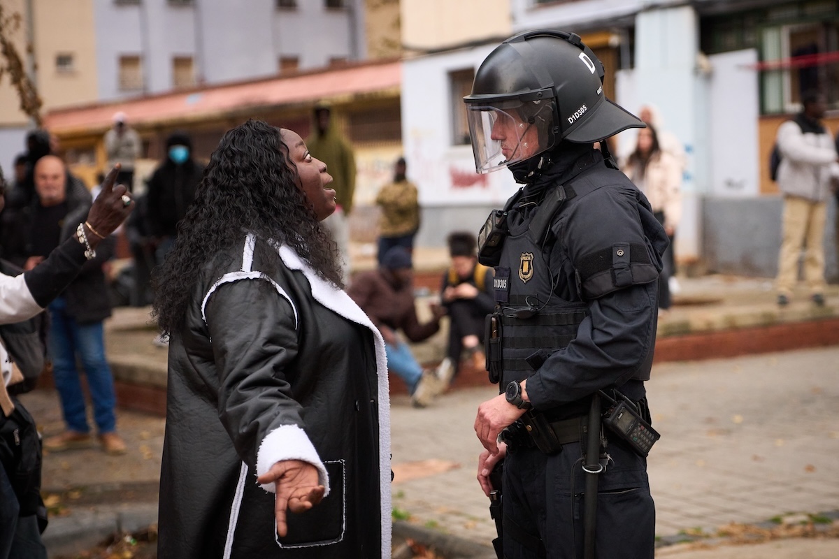 Una donna migrante discute con un poliziotto durante lo sgombero del B9, il 17 dicembre 2025 (AP Photo/Emilio Morenatti)