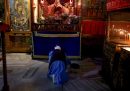 Una donna prega nella Basilica della Natività, costruita sopra la grotta in cui si crede sia nato Gesù, il 24 dicembre a Betlemme