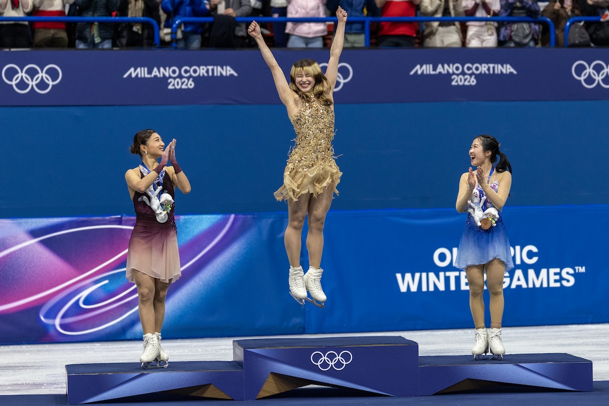 Alysa Liu, in mezzo, festeggia mentre riceve la medaglia d'oro alle Olimpiadi invernali di Milano Cortina, 19 febbraio 2026 (Tim Clayton/Getty Images)