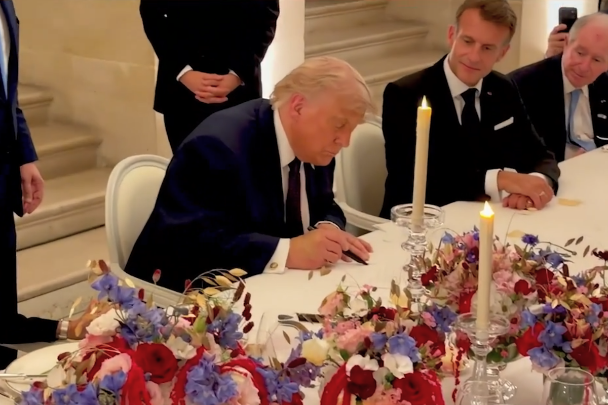 Trump che firma la copia dell'accordo durante una cena a Versailles, in un video diffuso dalla Casa Bianca